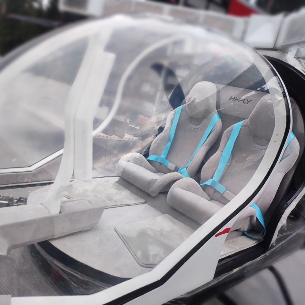 Аэротакси Hi-Fly, интерьер кокпита, два кресла с голубыми ремнями, вид сбоку